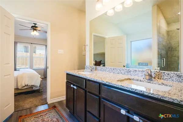 a en suite bathroom with a granite countertop sink and a mirror