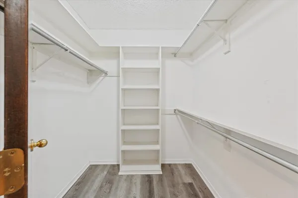 a view of walk in closet with empty racks