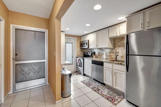 a kitchen with a refrigerator and a sink