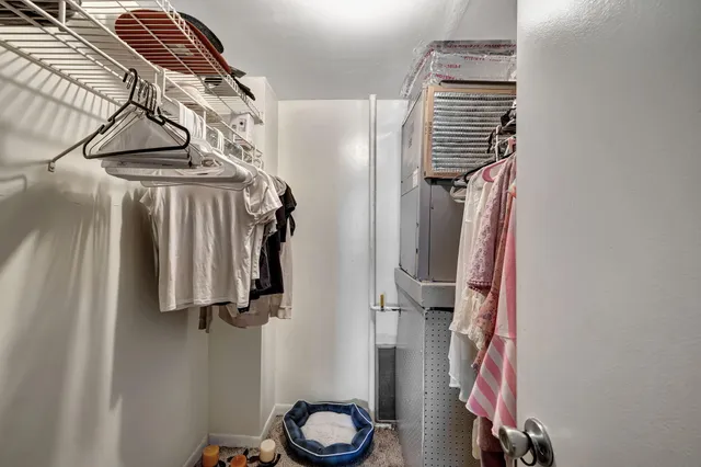 a view of walk in closet with clothes and shoes