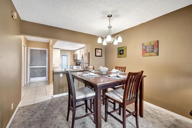 a view of a dining room with furniture and a chandelier