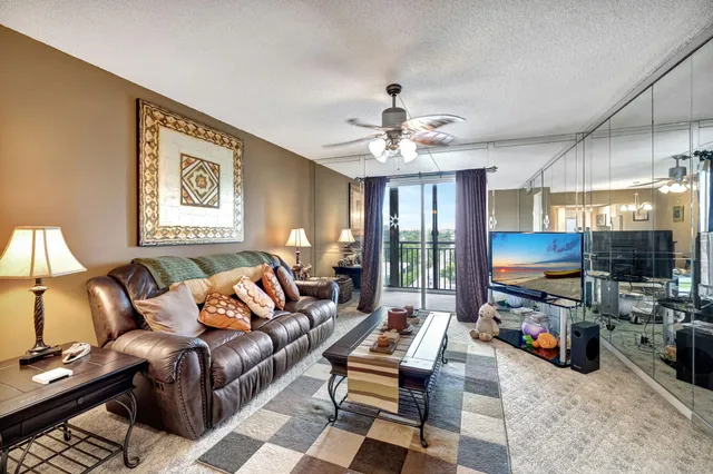 a living room with furniture a chandelier and a flat screen tv