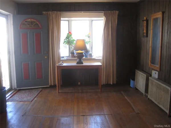 a living room with a mirror furniture and a window