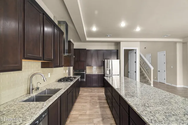 a large kitchen with granite countertop lots of counter space and a sink