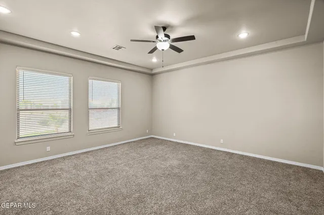 an empty room with window and ceiling fan