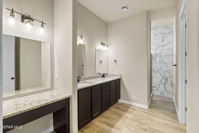 a bathroom with a granite countertop sink and a mirror