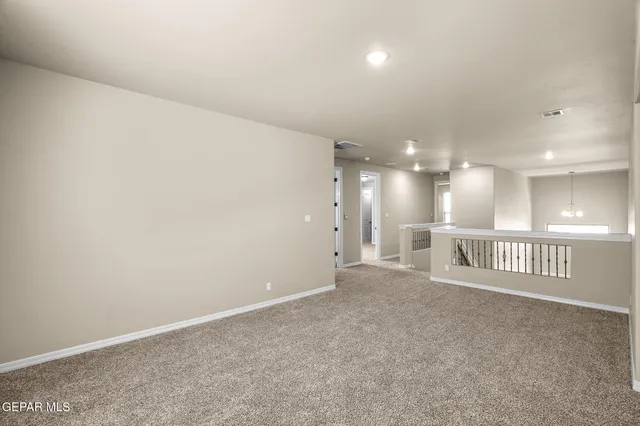 an empty room with staircase and fence