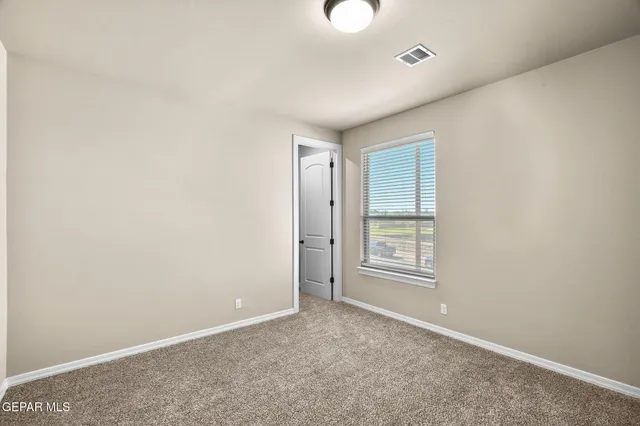 an empty room with windows and closet