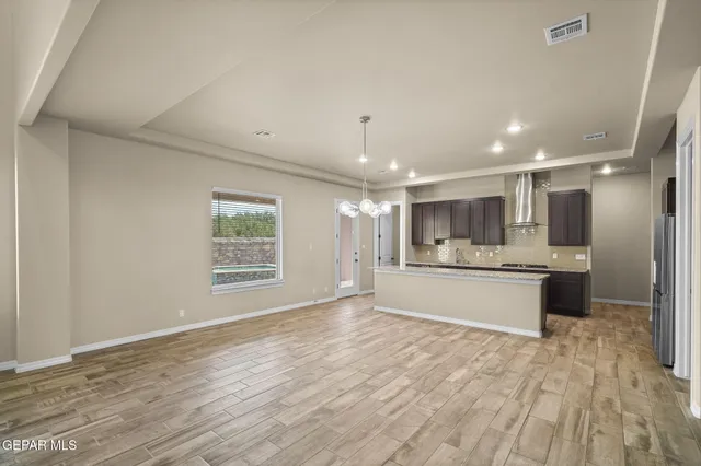a large kitchen with stainless steel appliances kitchen island a large counter top and a wooden floors