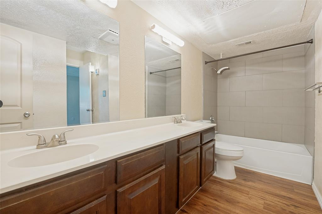 7305 Pineberry Road Dallas, TX 75249 - Photo 16 of 25 a bathroom with a double vanity sink toilet and shower