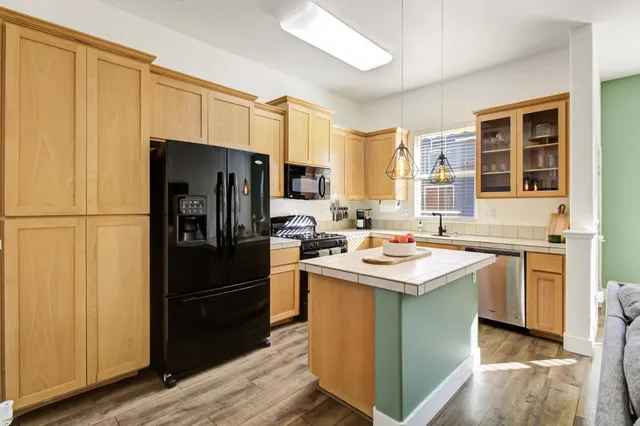 a kitchen with kitchen island a sink stove and refrigerator