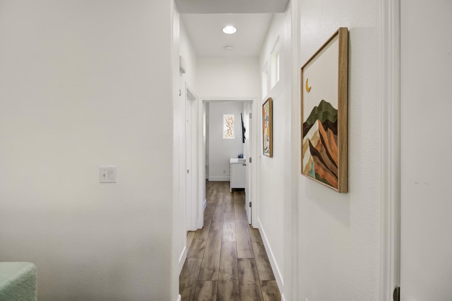 10890 Disk Drive Rancho Cordova, CA 95670 - Photo 20 of 43 a view of a hallway with wooden floor and a bathroom