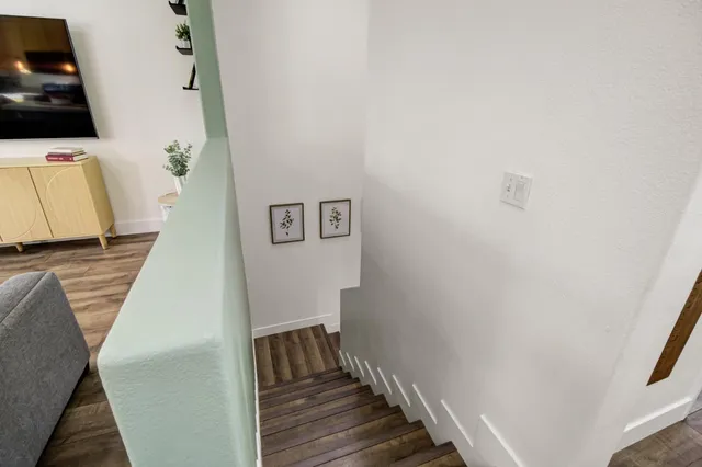 a view of a livingroom with wooden floor and stairs
