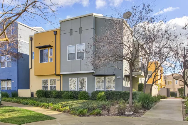 a front view of a residential houses with yard and trees