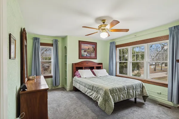 a bedroom with a large bed and a chandelier