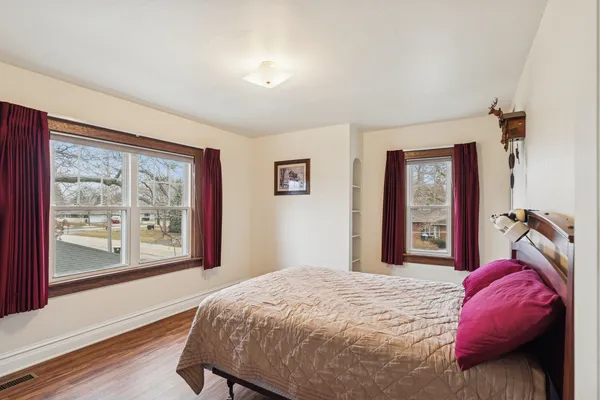 a bedroom with a bed and a large window