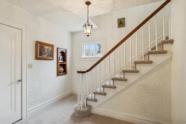 a view of staircase with lots of frames on wall and frames on a wall