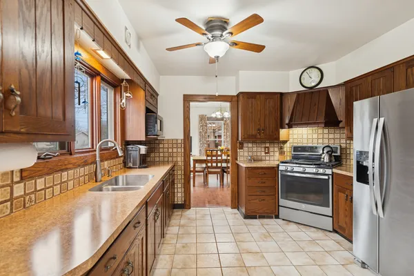 a kitchen with stainless steel appliances granite countertop a sink a stove and a refrigerator