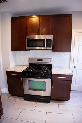 a kitchen with stainless steel appliances granite countertop a stove a microwave and a sink