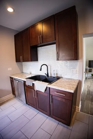 a kitchen with granite countertop a sink a stove and cabinets