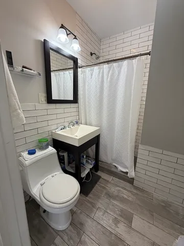 a bathroom with a toilet a sink and mirror