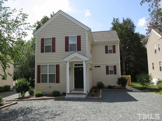 a view of a white house with a large windows yard and a large tree