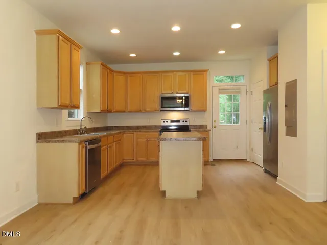 a kitchen with a refrigerator and a stove top oven