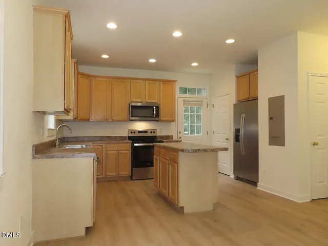 a kitchen with stainless steel appliances granite countertop a refrigerator stove microwave and sink