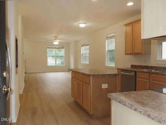 a kitchen with a sink a stove cabinets and wooden floor