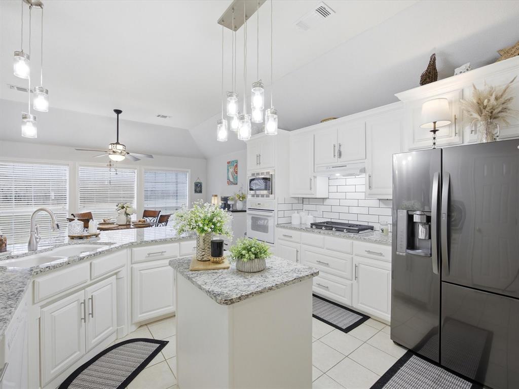 321 Niki Road Paradise, TX 76073 - Photo 11 of 40 a kitchen with white cabinets and stainless steel appliances
