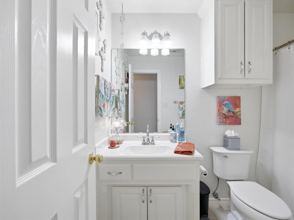 321 Niki Road Paradise, TX 76073 - Photo 24 of 40 a bathroom with a sink a toilet and a mirror