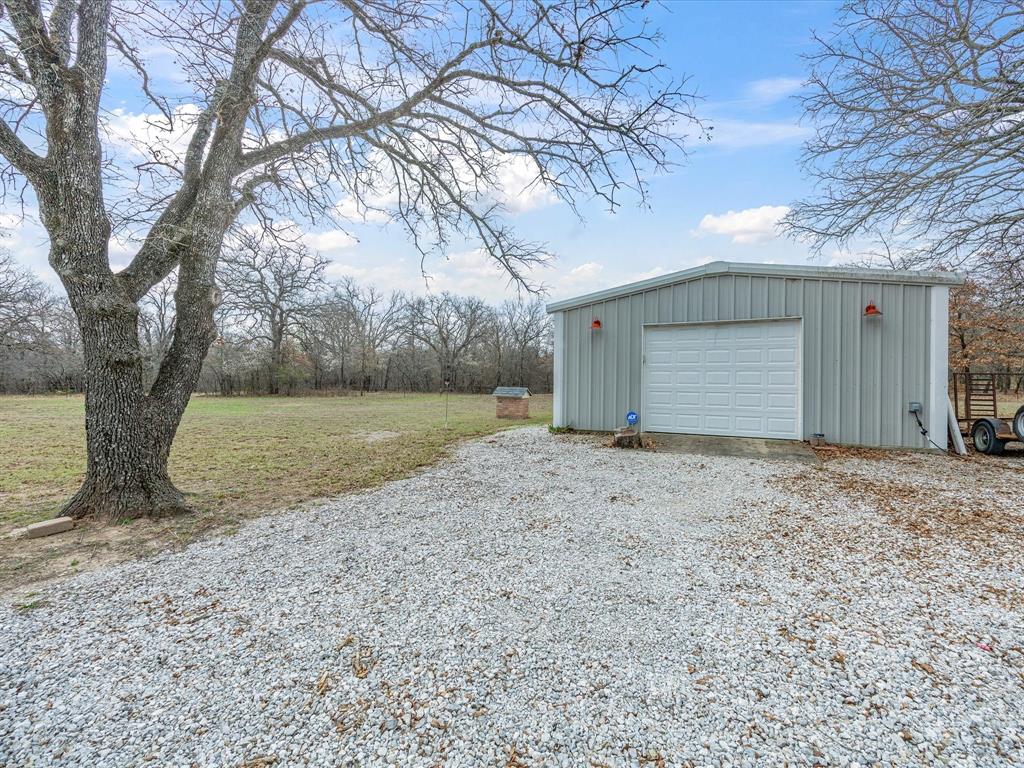 321 Niki Road Paradise, TX 76073 - Photo 30 of 40 a view of a house with a yard and large tree