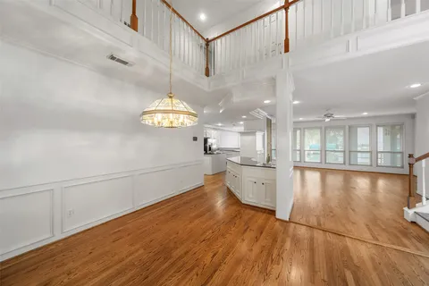 a view of a kitchen with refrigerator and wooden floor