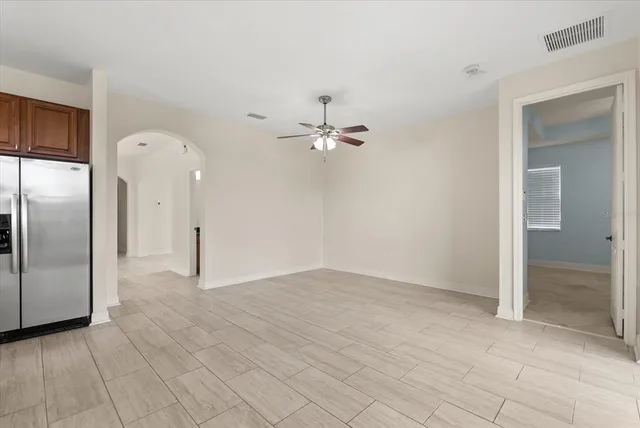 an empty room with fan and entrance