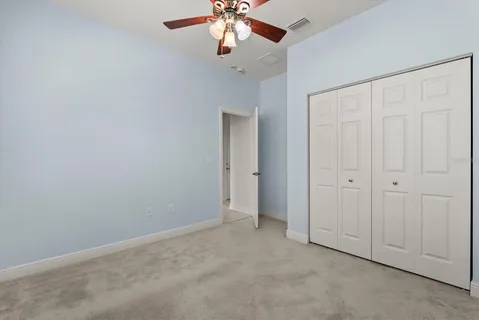 an empty room with chandelier fan