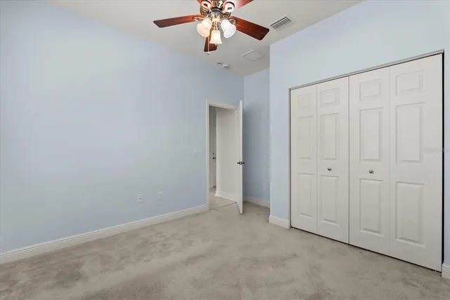 an empty room with chandelier fan