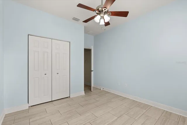 an empty room with windows and fan