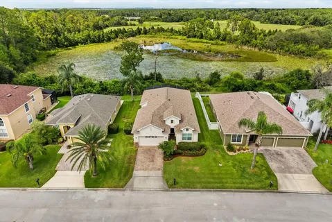 an aerial view of residential houses with outdoor space and parking