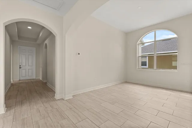 an empty room with wooden floor and mirror