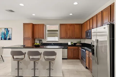 a kitchen with granite countertop wooden cabinets and stainless steel appliances