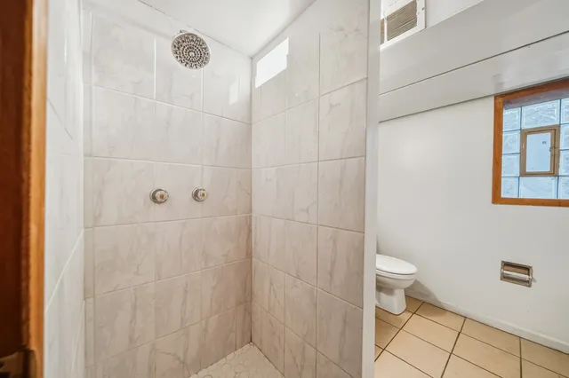 a view of a room with wooden floor mirror and windows