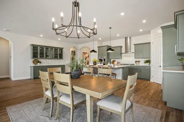 a view of a dining room and livingroom with furniture wooden floor a chandelier