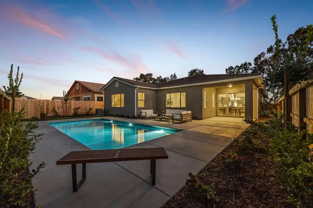 a front view of a house with swimming pool and porch