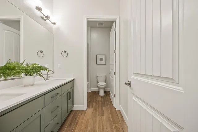 a bathroom with a granite countertop sink a toilet and shower