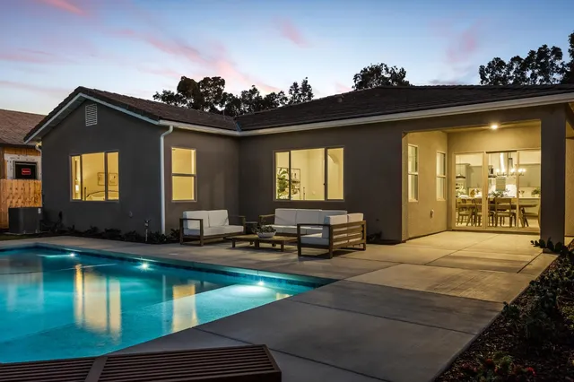 a view of a house with swimming pool and sitting area