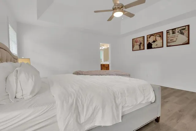 a bedroom with a large bed and a chandelier