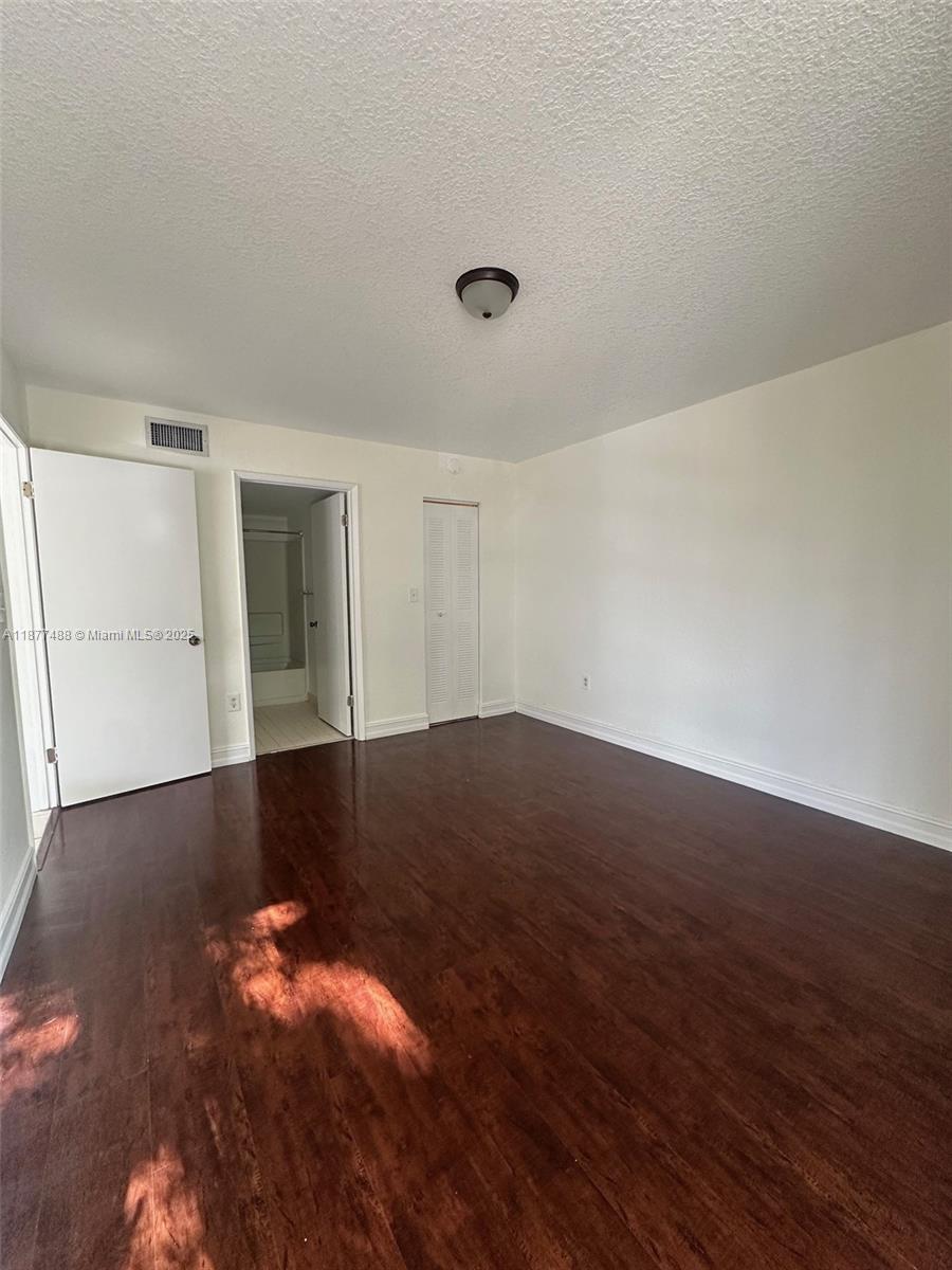 7125 Northwest 186th Street, Unit B208 Hialeah, FL 33015 - Photo 4 of 10 a view of a room with wooden floor and window