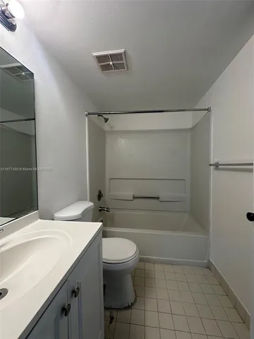 a bathroom with a granite countertop sink toilet a mirror and shower