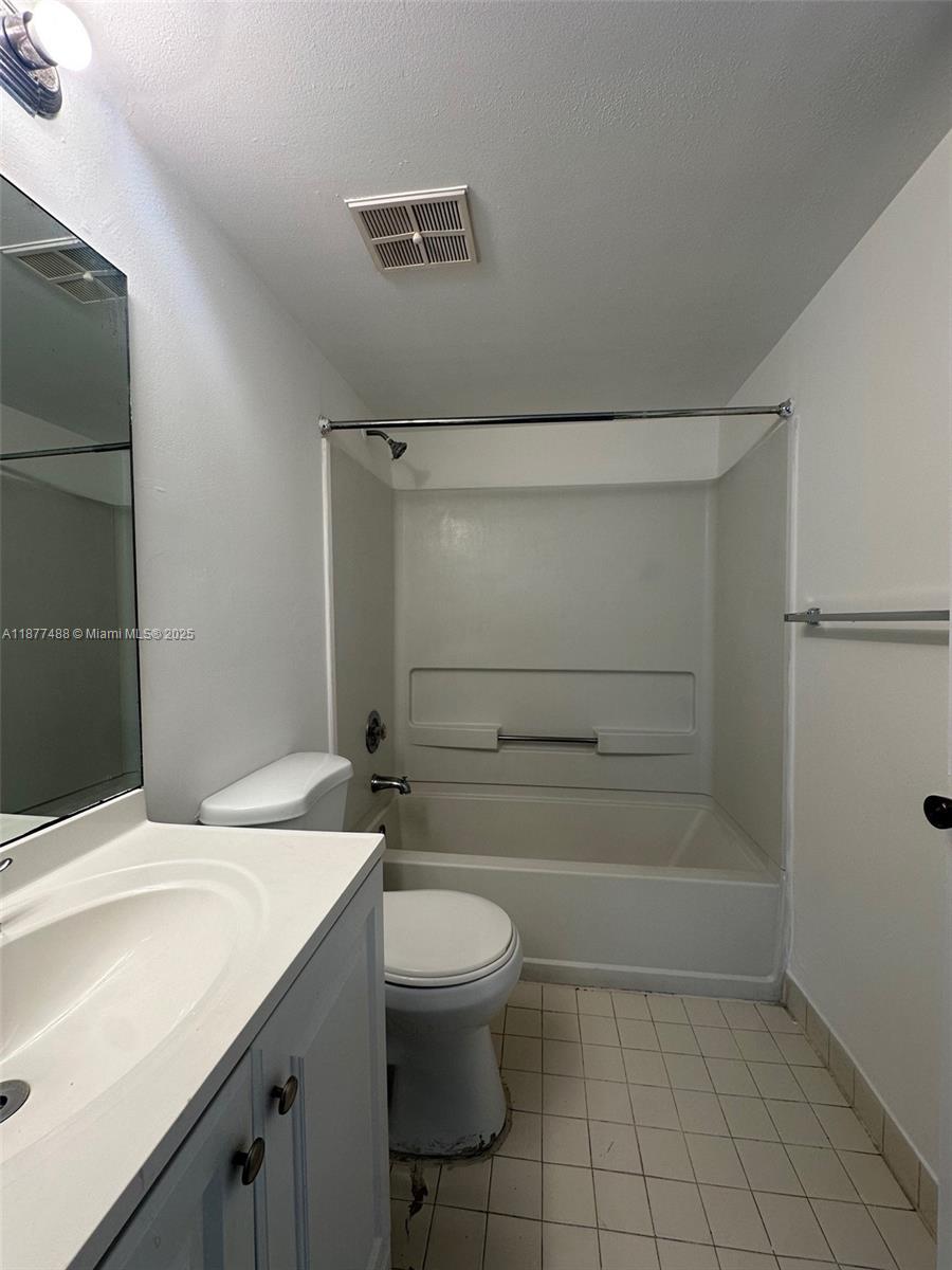 7125 Northwest 186th Street, Unit B208 Hialeah, FL 33015 - Photo 5 of 10 a bathroom with a granite countertop sink toilet a mirror and shower