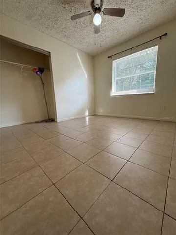 an empty room with windows and fan